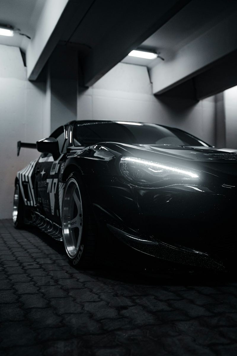 Carro esportivo preto rebaixado em garagem